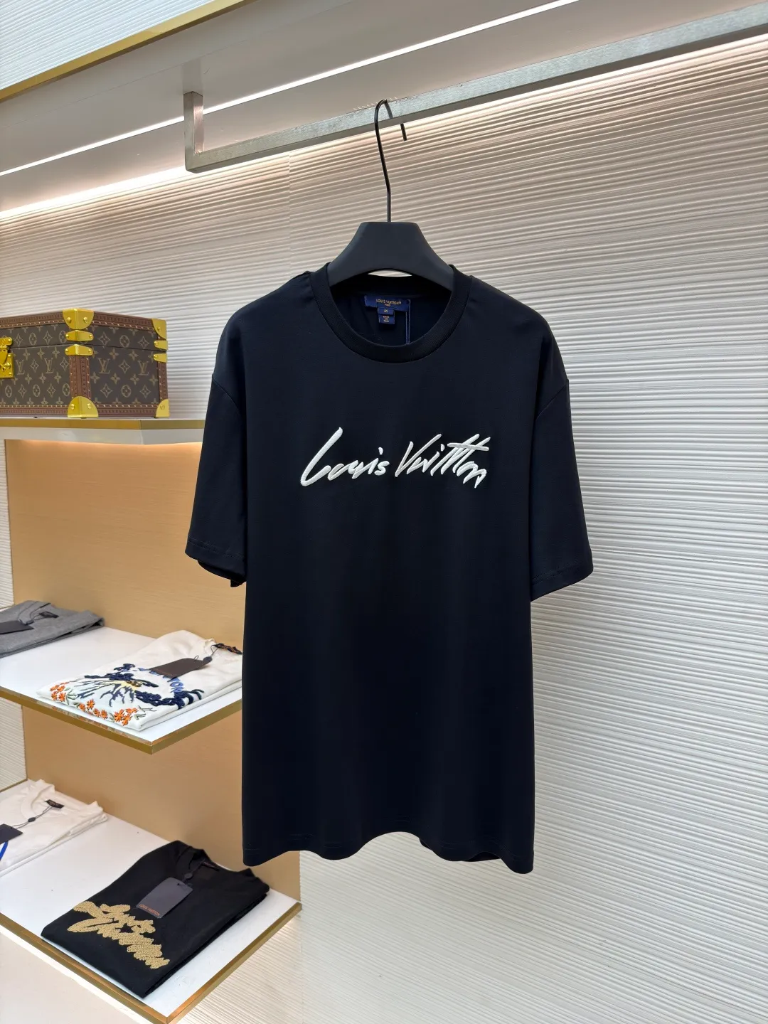 LOUIS VUITTON round neck short sleeves with hand lettering embroidery ●Item number: 1681408-X95 ●Material: long-staple cotton fabric ●Technology: embroidery production ●Color: black ●Version: fitted version ●Weight: about 230 grams ●Size: S-M-L-XL ●Description: Restore 60S single yarn double-sided long-staple cotton, weight 170g; with 32S 1×1 thread, 300g. After being treated with liquid ammonia, it looks like a water-gloss machine. The cloth surface is smooth and has a clear texture, with a slight luster and strong texture. The cotton fiber length of the fabric is long. The advantage of this feature is that after being spun into yarn, the surface of the yarn is smoother, less rough and has a delicate feel. The thin and long features give it a flexible texture, soft skin feel and fabric luster. The front side shows the thickness changes of 3D handwritten font embroidery handwriting strokes and the design pattern after the continuous strokes are simplified; the three-dimensional effect is achieved through multi-layer embroidery threads, filling materials and special stitching methods. Jagged edges are prone to appear on curves and corners; add foam embroidery to the bottom layer of the embroidery and then cut off the excess to form a three-dimensional bulge and improve the smoothness of the lines. Standard H hanging fit with shoulder-length design. The vertical version emphasizes that the width of the shoulders, waist, and hem are basically the same, and it is simple and loose. The short sleeves are tailored to fit the body of the wearer. At the same time, the neckline, cuffs and hem of the short sleeves are all designed with double lines. The overall wiring is straight and delicate, the fabric is comfortable and soft, and the color is consistent without color difference. It can be matched with the same style to create a fashionable look and control various occasions. Customized accessories, complete with three standards, same style for men and women!